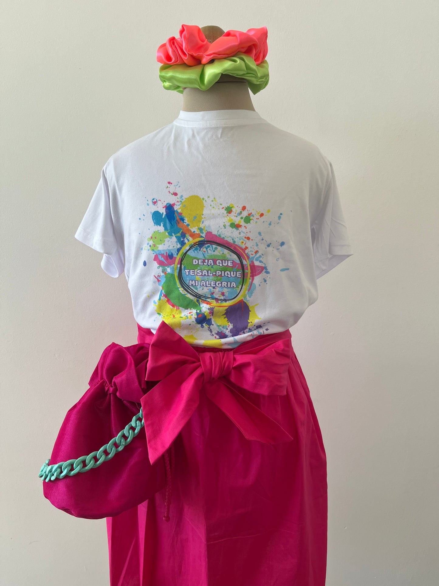 falda fucsia con lazo anudado al frente, con camiseta de colores y mochila fucsia